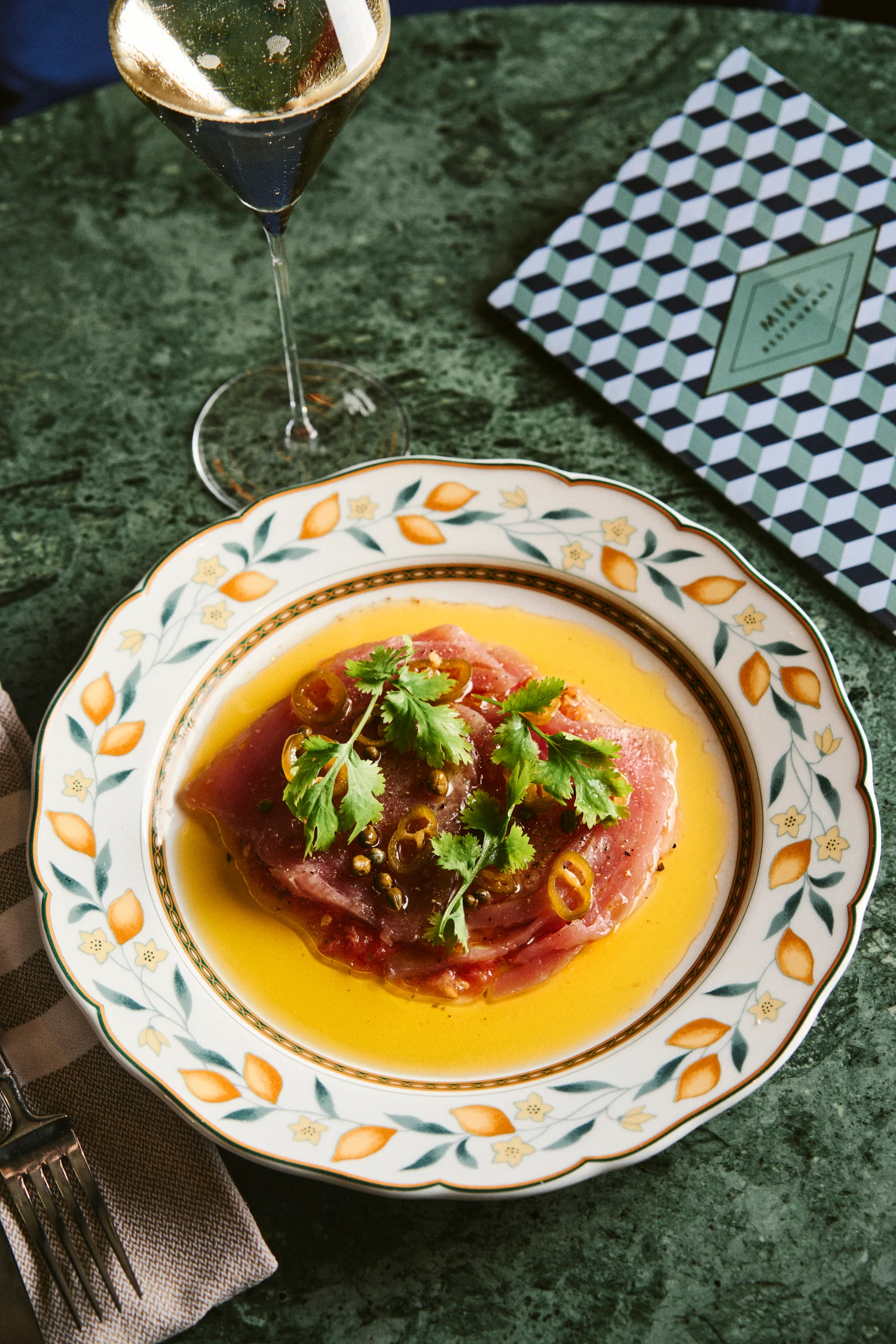 Thunfisch-Carpaccio mit Tomaten, Koriandergrün, eingelegten Chilis und Capperini